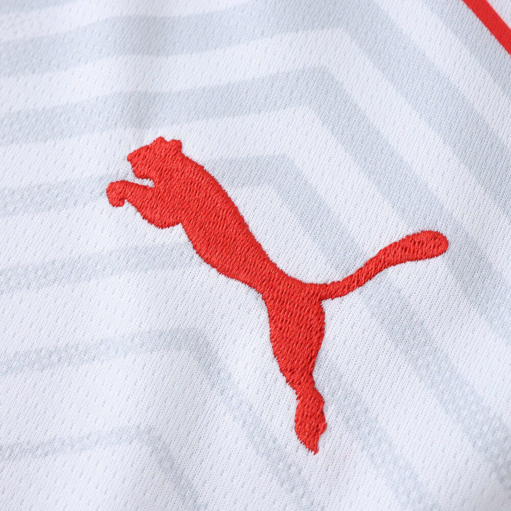 Close-up of the red Puma logo on the RB Leipzig 2025/26 Fan Version home jersey.