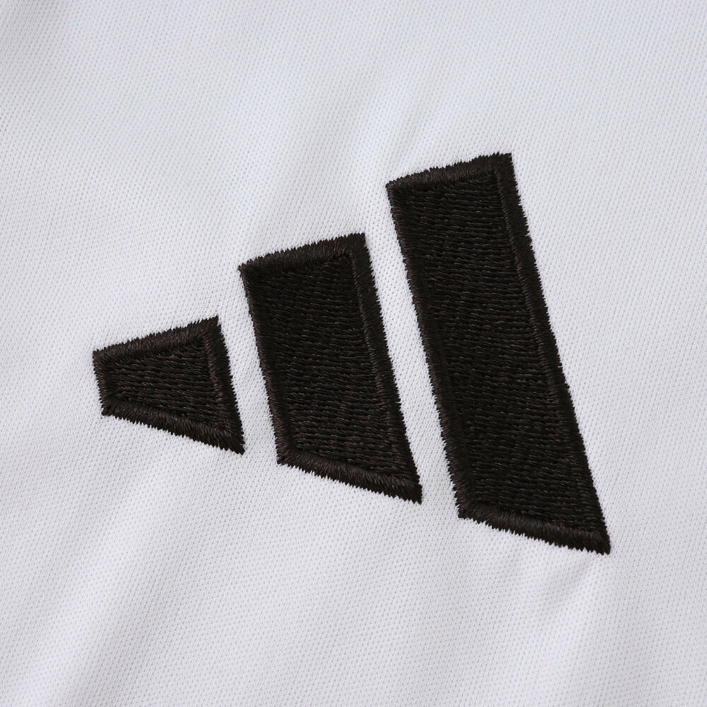 Close-up of the black Adidas logo on the Real Madrid 2025/26 Home Fan Version jersey.