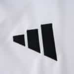 Close-up of the Adidas logo on the River Plate Home 2025/26 Fan Version jersey fabric.