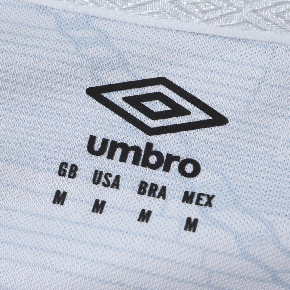 Close-up of Santos FC 2025/26 home jersey fabric showing Umbro logo and size details in black text.