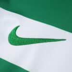Close-up of the green Nike logo on the Sporting CP 2025/26 home fan jersey.
