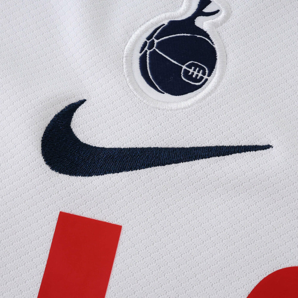 Close-up of Tottenham Hotspur 2025/26 Home Fan Version jersey showing crest and Nike logo on white fabric.