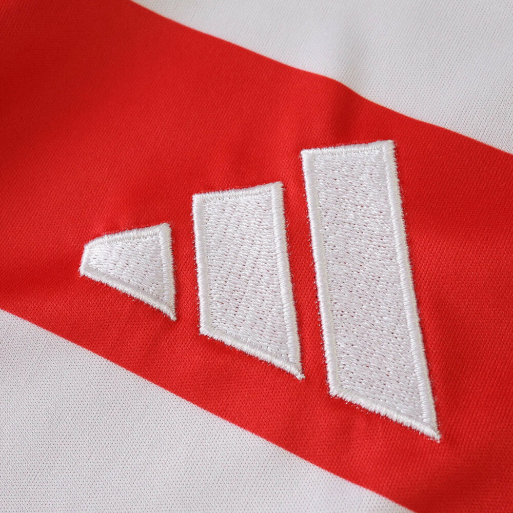 Close-up of the Adidas logo stitched on the Union Berlin 2025/26 Home Fan Version jersey.