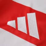 Close-up of the Adidas logo stitched on the Union Berlin 2025/26 Home Fan Version jersey.