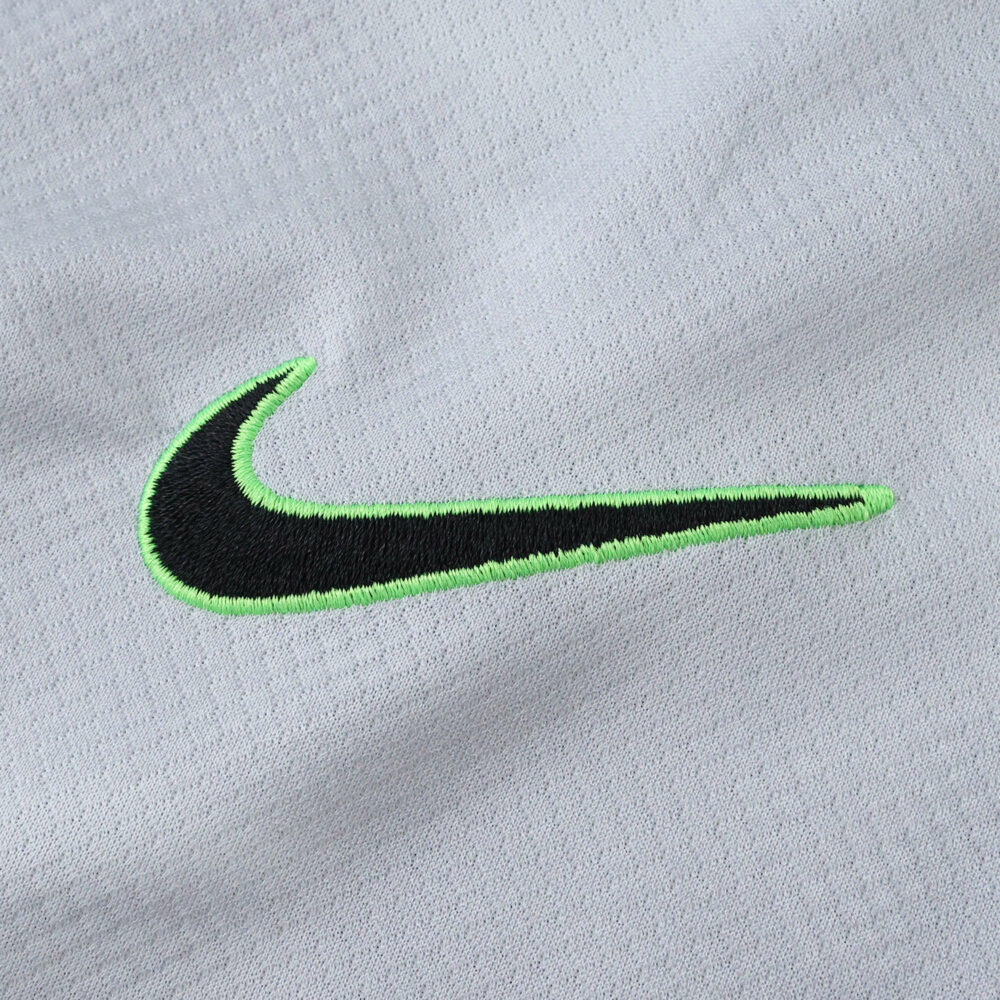 Close-up of the Nike logo on the VfL Wolfsburg 2025/26 Away Fan Version jersey in light gray fabric.