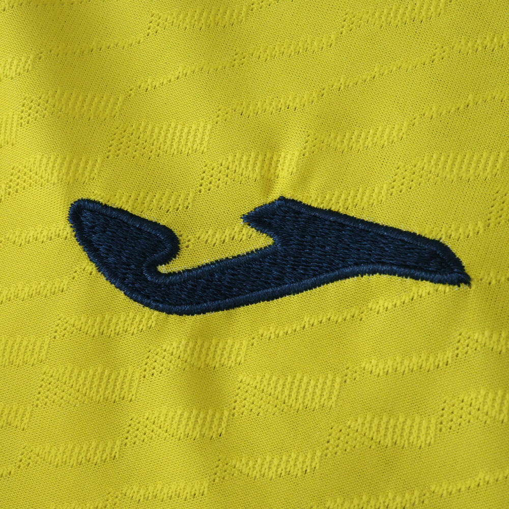Close-up of the Villarreal 2025/26 Player Version home jersey showing the navy Joma logo on yellow fabric.