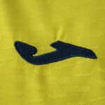Close-up of the Villarreal 2025/26 Player Version home jersey showing the navy Joma logo on yellow fabric.