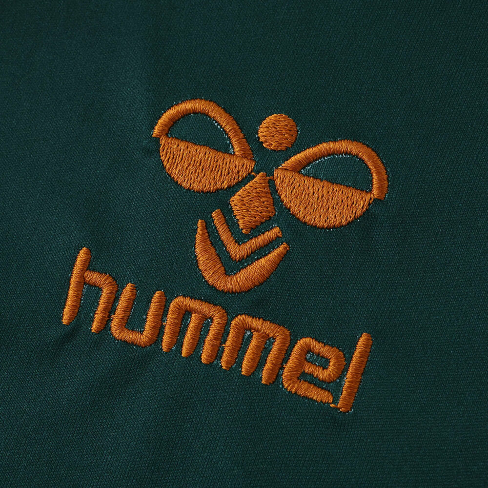 Close-up of the orange Hummel logo on the Werder Bremen Third 2025/26 Fan Version jersey.