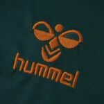 Close-up of the orange Hummel logo on the Werder Bremen Third 2025/26 Fan Version jersey.