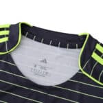 Close-up of Celtic Away 2025/26 Fan Version jersey neckline with neon stripes and Adidas logo.
