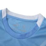 Close-up of Manchester City 2025/26 home fan jersey collar in light blue with white trim.