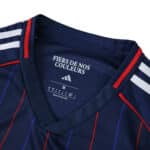 Close-up of Olympique Lyonnais 2025/26 away fan jersey collar with red trim and white stripes.