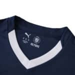 Close-up of PSV Eindhoven 2025/26 away fan jersey collar with white V-neck and Puma branding.