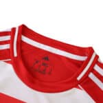 Close-up of the collar and shoulder detail on the Union Berlin 2025/26 home fan jersey, featuring red and white colors.