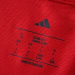 Close-up of the inner neck label on the Ajax Home 2025/26 Fan Version jersey showing size and fit details.