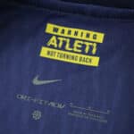 Close-up of the Atlético Madrid Away 2025/26 Player Version collar with "Warning Atleti Not Turning Back" text.