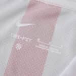 Close-up of Atlético Madrid 2025/26 home fan jersey showing Nike logo and DRY-FIT label on red and white fabric.