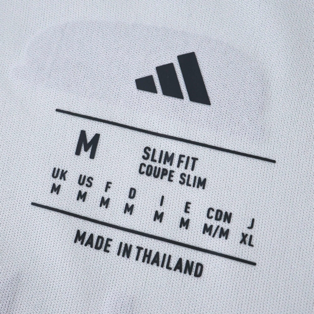 Close-up of Bayern Munich Away 2025/26 Fan Version shirt tag showing size and slim fit details.