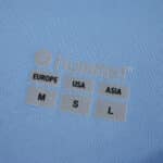 Close-up of Celta Vigo 2025/26 fan jersey label showing Hummel logo and size chart for Europe, USA, and Asia.