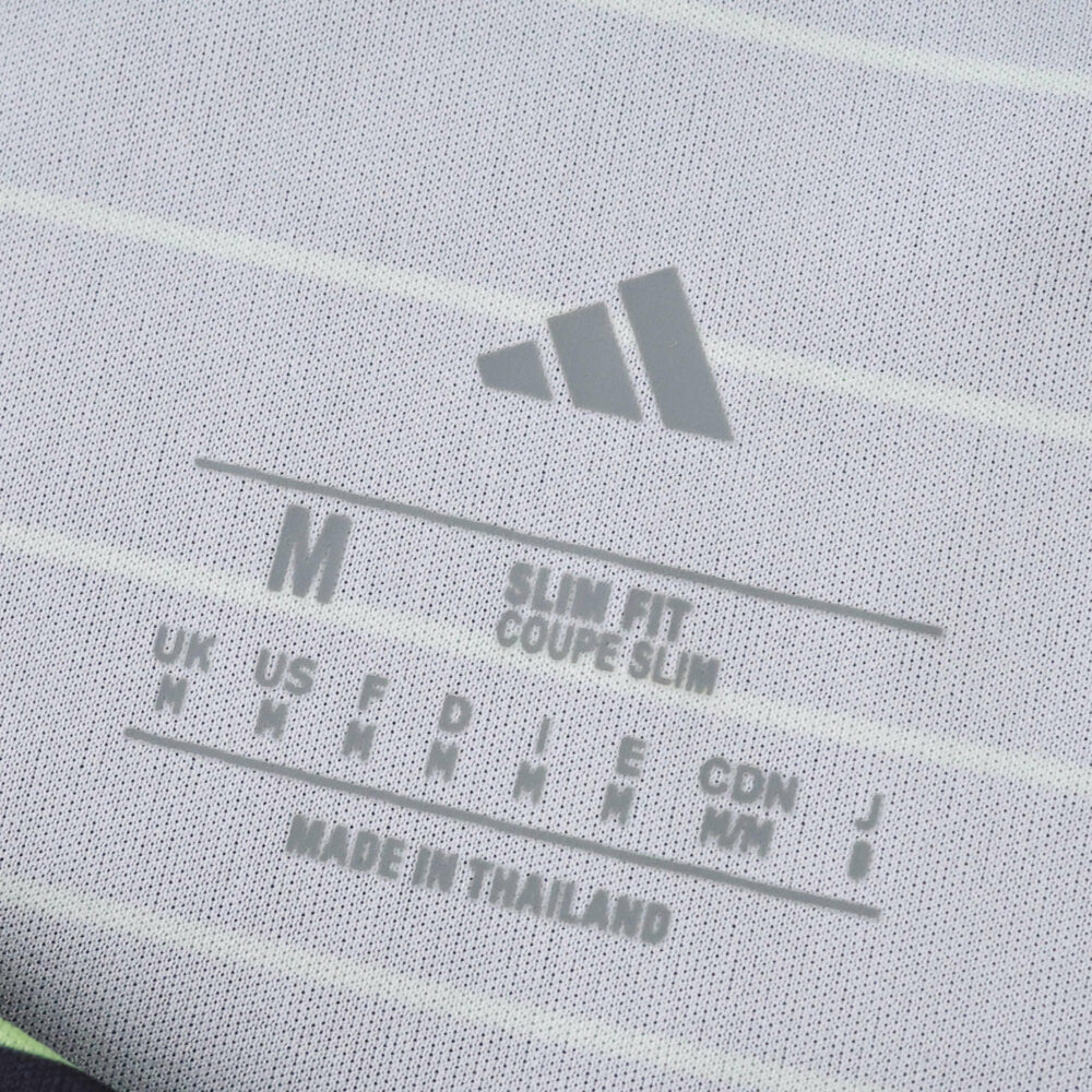 Close-up of Celtic Away 2025/26 Fan Version jersey tag showing size, fit details, and brand logo.