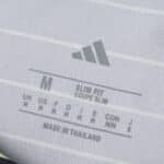Close-up of Celtic Away 2025/26 Fan Version jersey tag showing size, fit details, and brand logo.