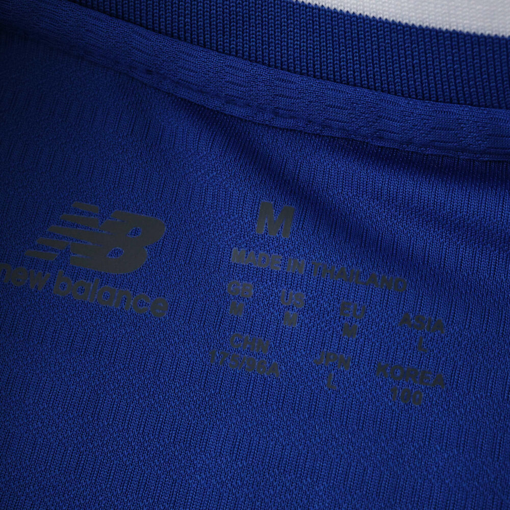 Close-up of FC Porto 2025/26 home fan jersey neckline with New Balance logo and size details.
