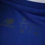 Close-up of FC Porto 2025/26 home fan jersey neckline with New Balance logo and size details.