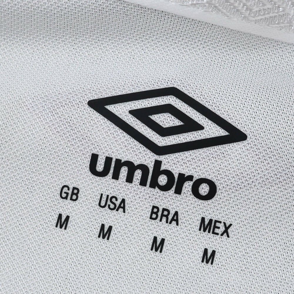 Close-up of Umbro logo and size chart printed on Fluminense Away 2025/26 Fan Version jersey fabric.