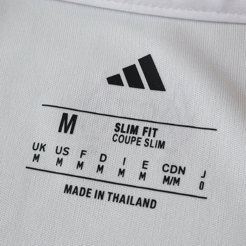 Close-up of Liverpool Away 2025/26 Fan Version shirt tag showing Adidas logo, size M, slim fit.