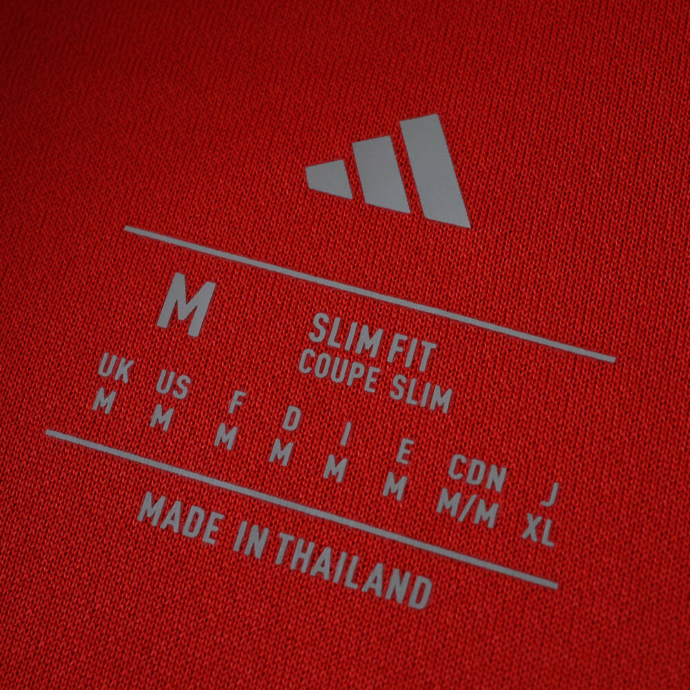 Close-up of the Liverpool Home 2025/26 Fan Version tag showing size M, slim fit, and made in Thailand.