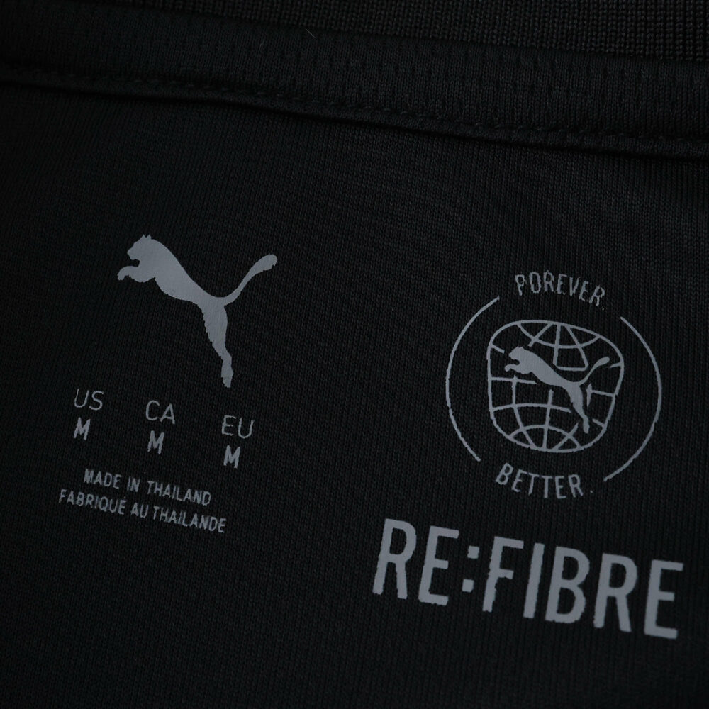 Close-up of interior label on Manchester City 2025/26 away fan jersey showing Puma and sustainability logos.