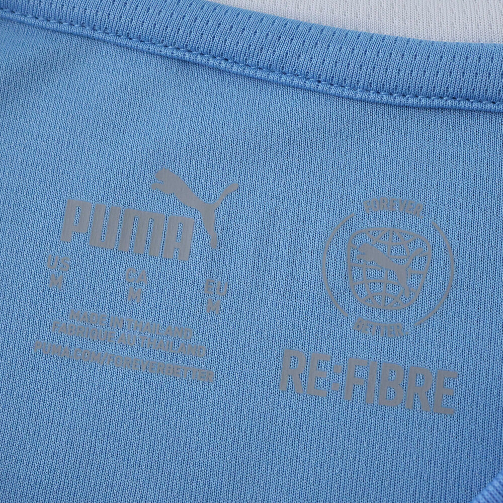 Close-up of Manchester City 2025/26 Home Fan Version collar featuring Puma logo and RE:FIBRE label.