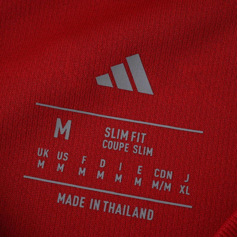 Close-up of Manchester United 2025/26 Home Fan Version shirt label showing size M and slim fit details.