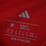 Close-up of Manchester United 2025/26 Home Fan Version shirt label showing size M and slim fit details.