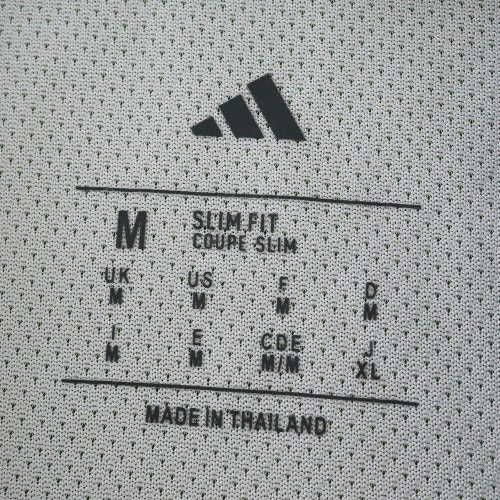Neck label of the Newcastle United 2025/26 Player Version home shirt, showing size M and slim fit details.