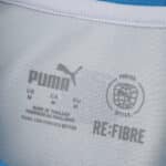 Close-up of Olympique Marseille 2025/26 Home Fan jersey collar with Puma and RE:FIBRE logos.
