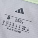 Close-up of the Real Madrid Away 2025/26 Fan Version shirt's size and fit label, showing "Slim Fit."
