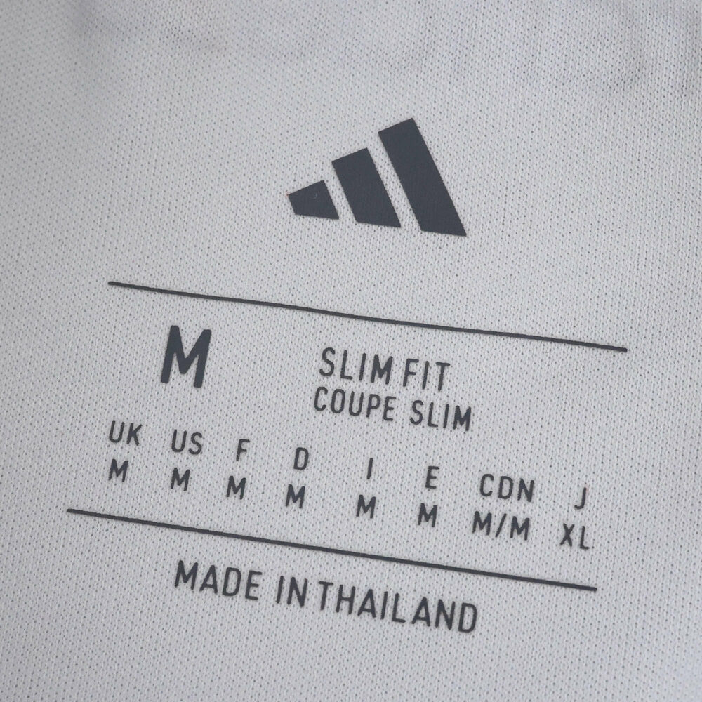 Close-up of the River Plate Home 2025/26 Fan Version jersey size label showing medium, slim fit, made in Thailand.