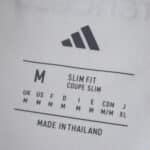 Close-up of the River Plate Home 2025/26 Fan Version jersey size label showing medium, slim fit, made in Thailand.