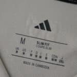 Inside label of SL Benfica Away 2025/26 Fan Version shirt showing size M and slim fit details.
