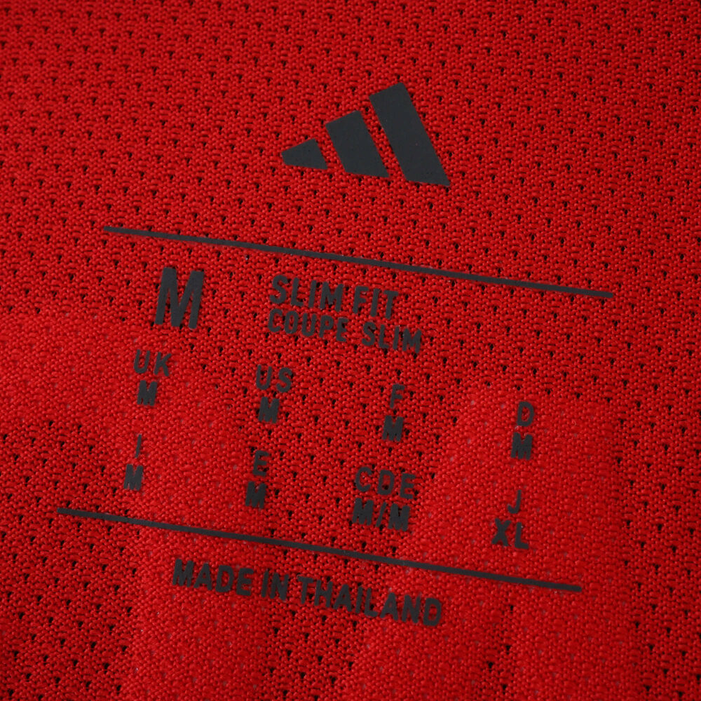 Close-up of SL Benfica Home 2025/26 Player Version jersey size label on red fabric.