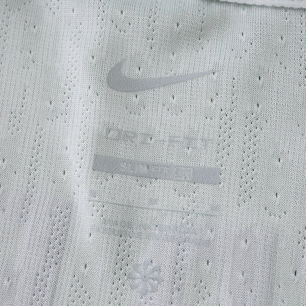 Close-up of the Sporting CP 2025/26 Home Player Version jersey fabric with Nike logo and ventilation details.