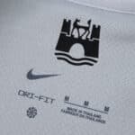 Close-up of VfL Wolfsburg Away 2025/26 Fan Version inner collar with logo, Nike Dri-Fit, and size details.