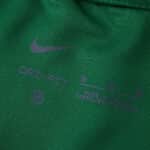 Close-up of the VfL Wolfsburg 2025/26 home fan jersey collar with Nike logo and product details.