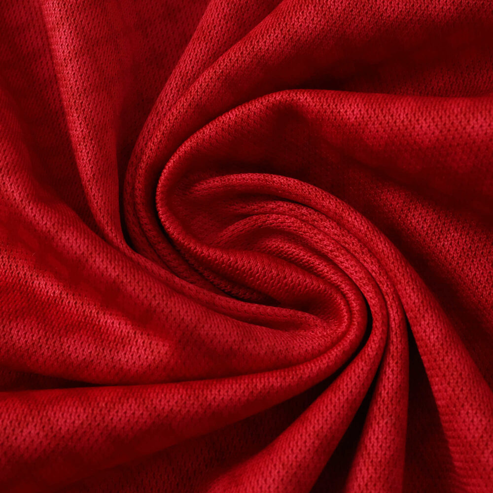 Close-up of the red fabric used in the Ajax Home 2025/26 Fan Version jersey, showing its texture and weave.