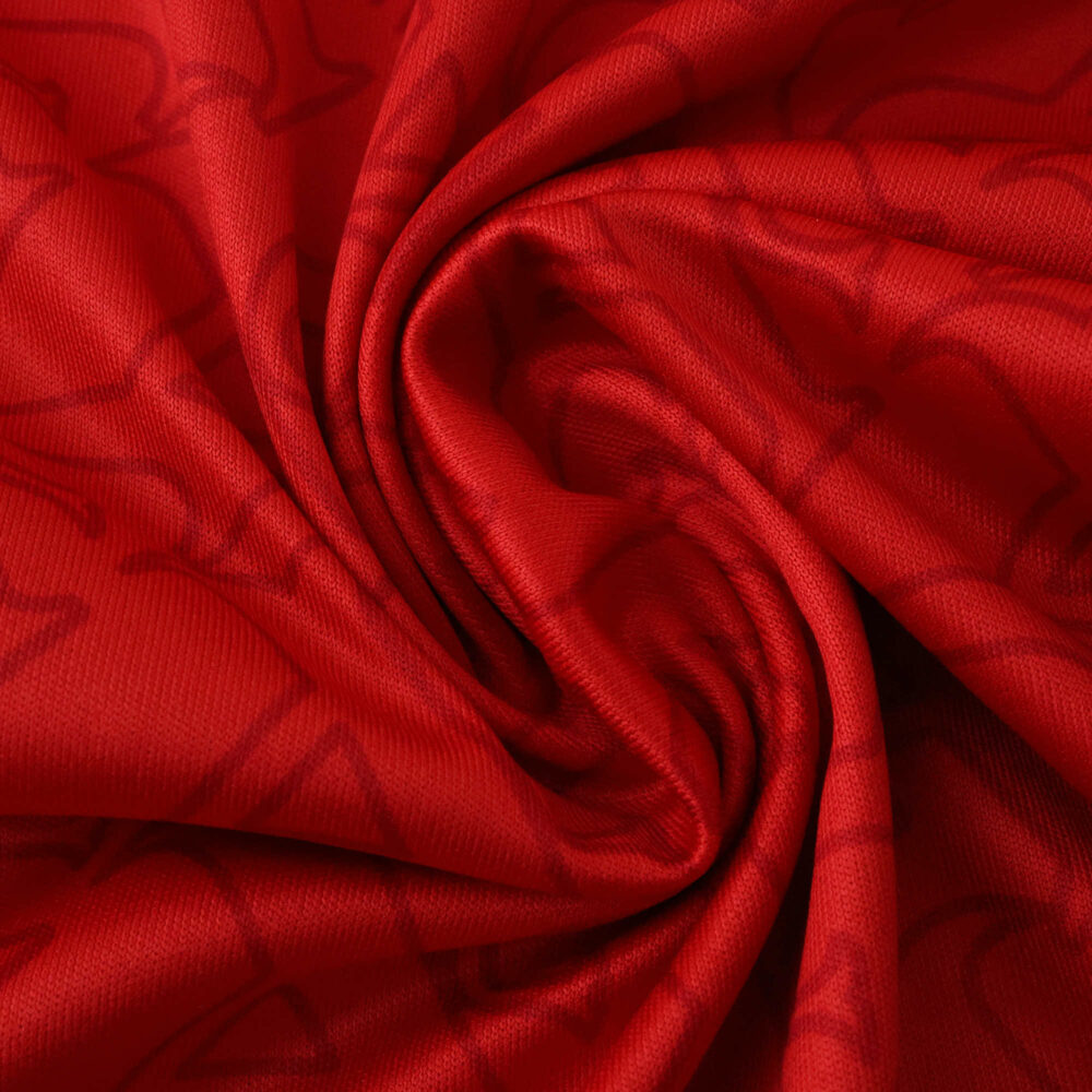 Close-up of red Arsenal Home 2025/26 Fan Version jersey fabric with subtle pattern detail.