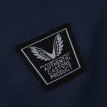 Close-up of the Castore logo patch on the Athletic Bilbao 2025/26 away fan jersey in dark blue fabric.