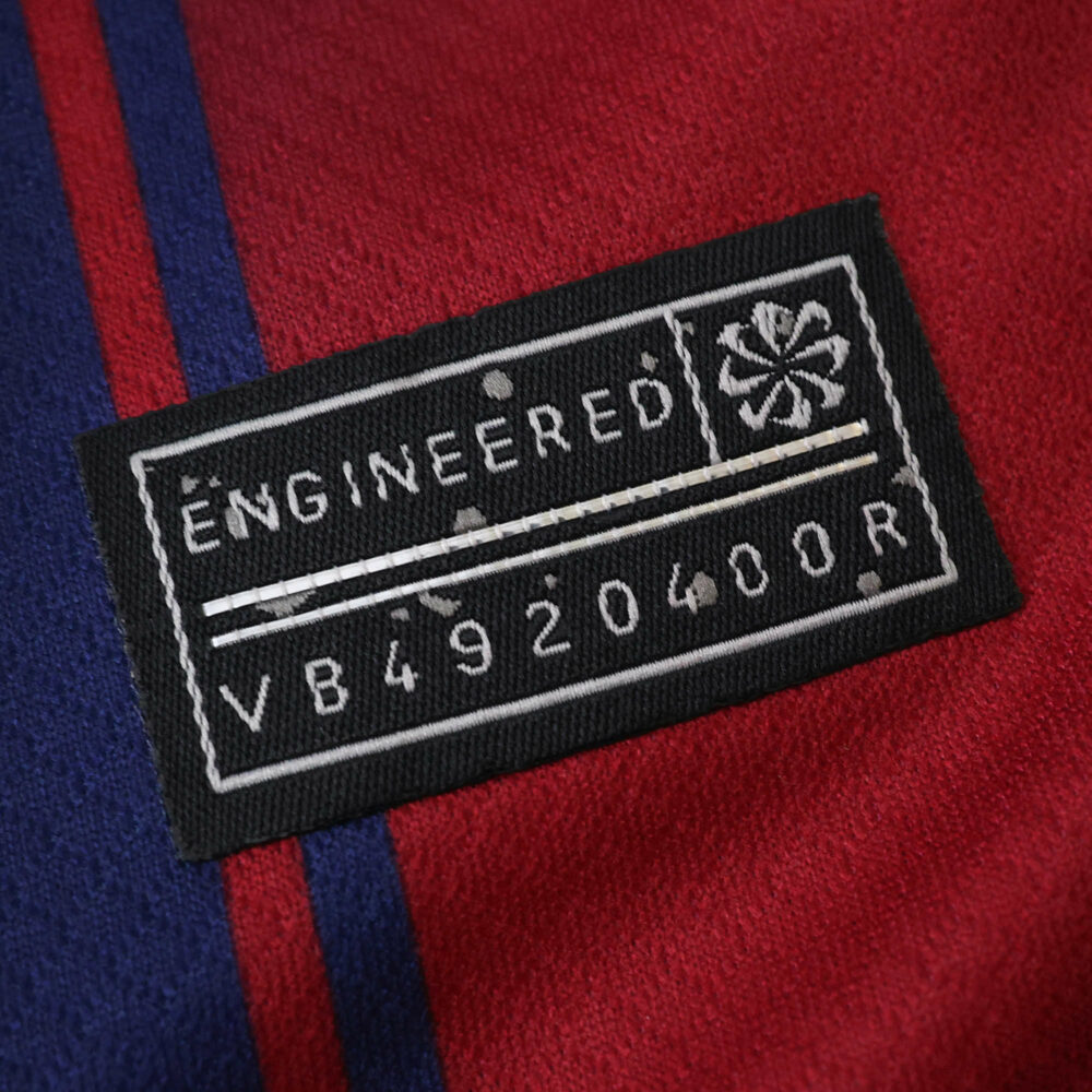 Close-up of the engineered label on the 2025/26 Barcelona Home Fan Version jersey fabric.