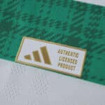 Close-up of the gold Adidas Authentic Licensed Product badge on the 2025/26 Celtic Home Player Version shirt.