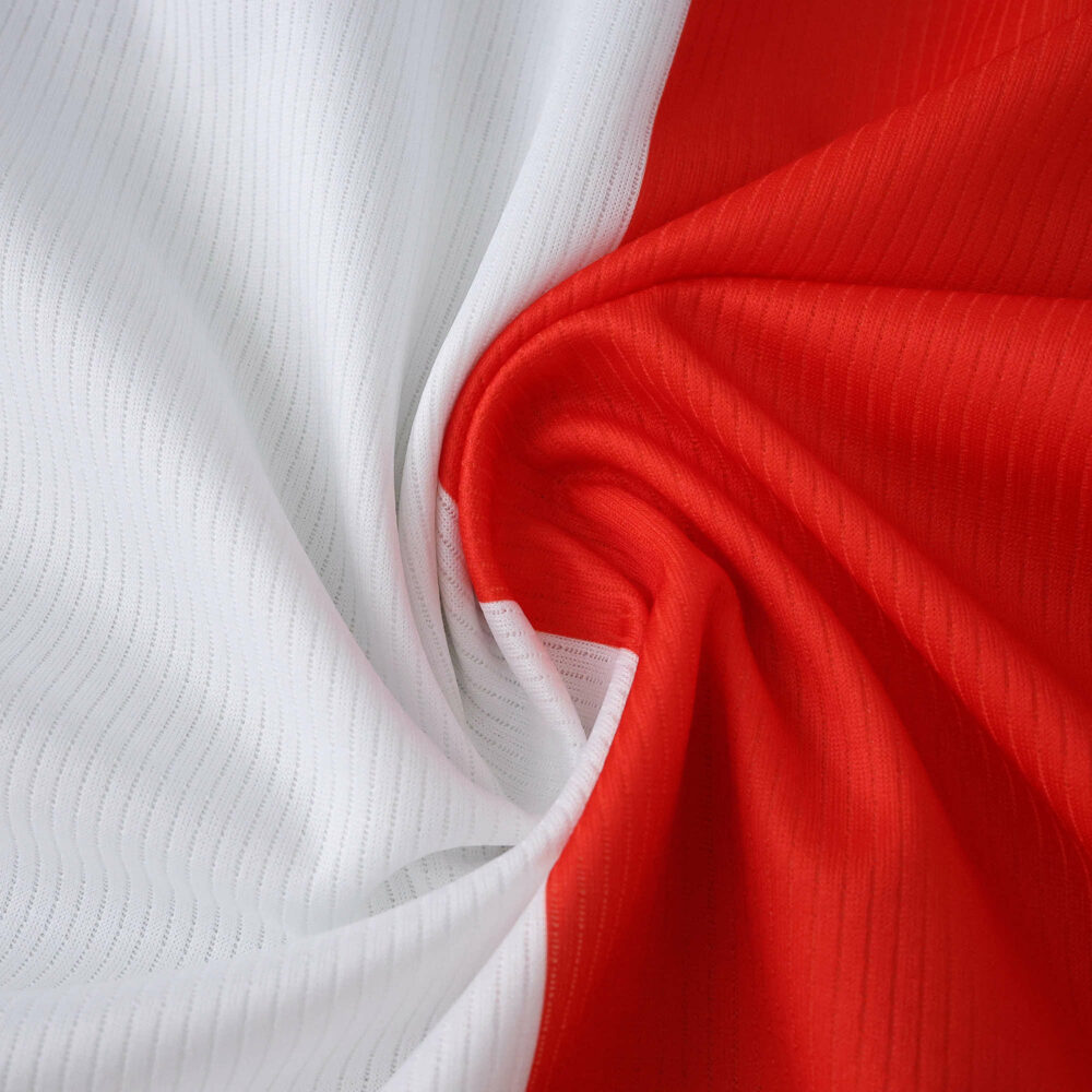Close-up of Feyenoord Home 2025/26 fan jersey fabric showing red and white colors.